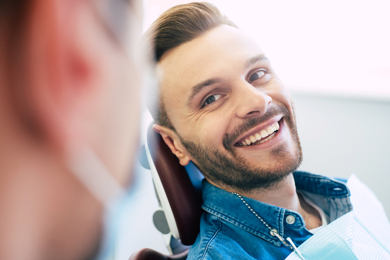 Man smiling a stunning smile after receiving orthodontic treatment