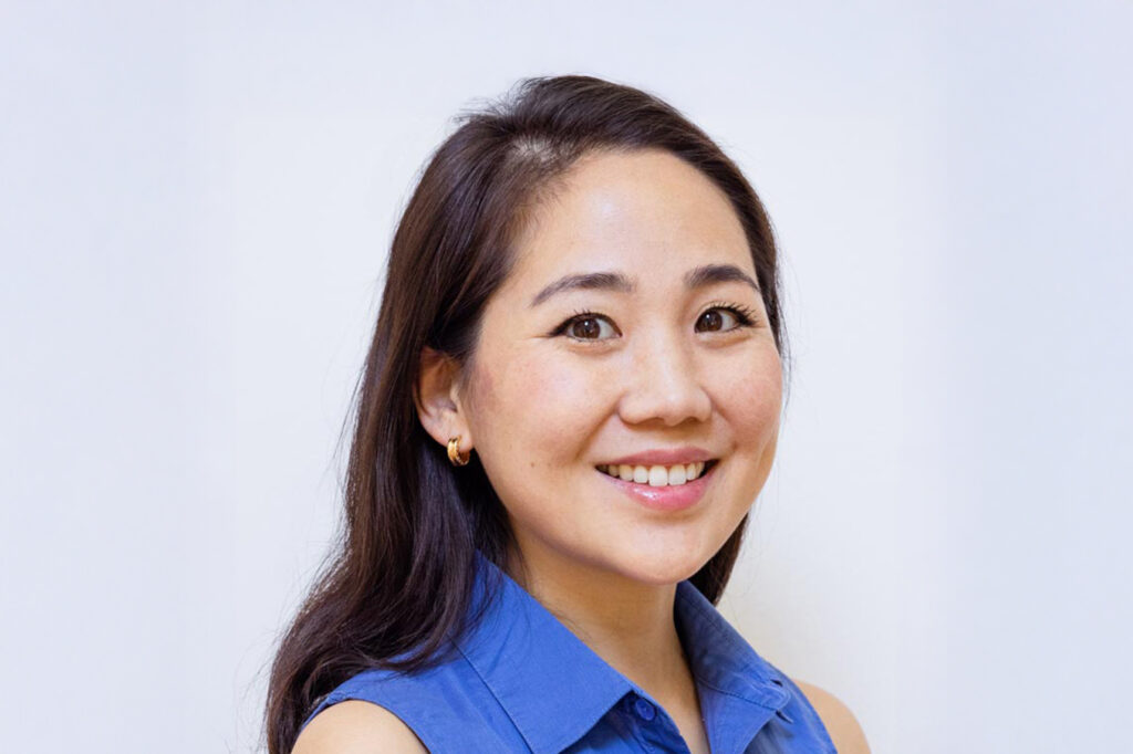 Newark and Wilmington, DE orthodontist Dr. Yi smiling in a blue top