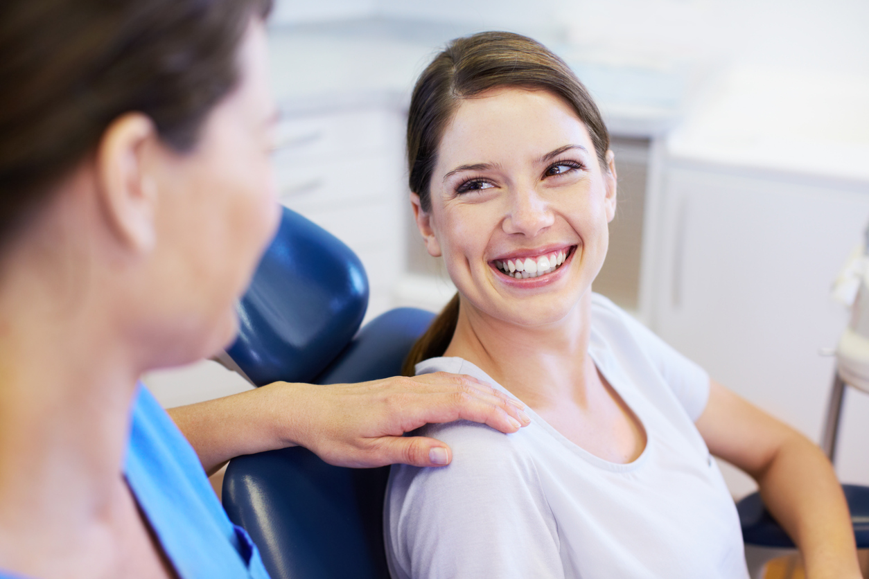 Woman smiling up at an orthodontic assistant with a graphic that says “25+ Years of Excellence”