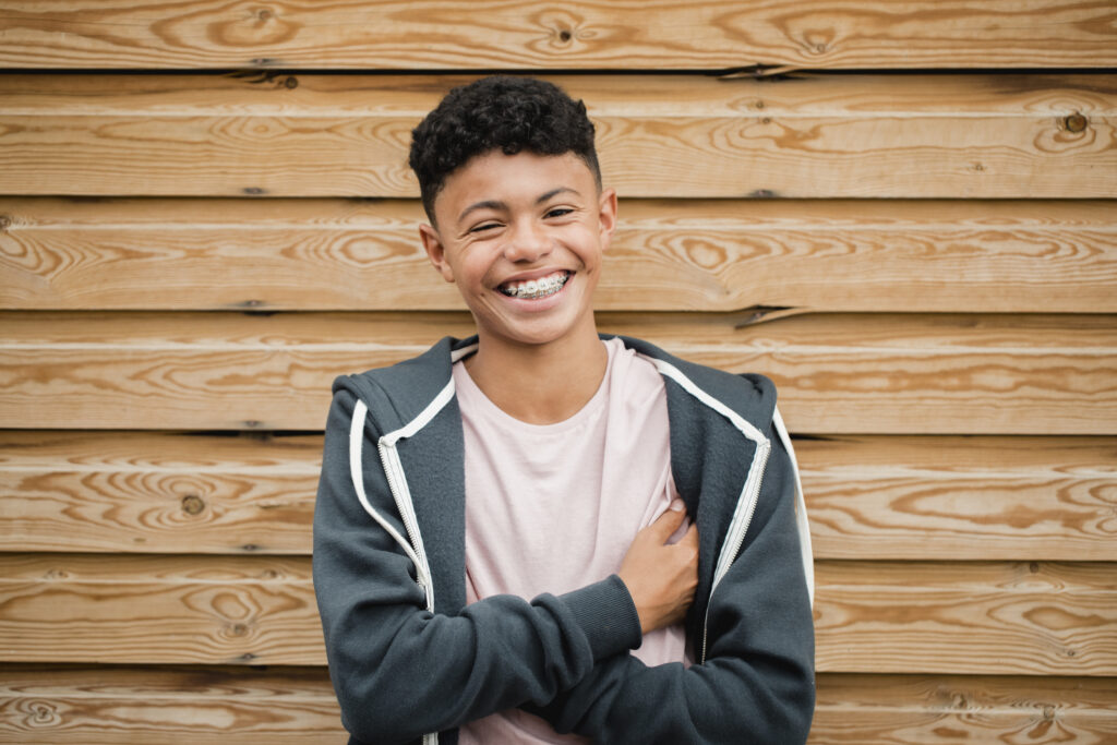 Teen with braces and a vibrant smile coming out of his shell and smiling